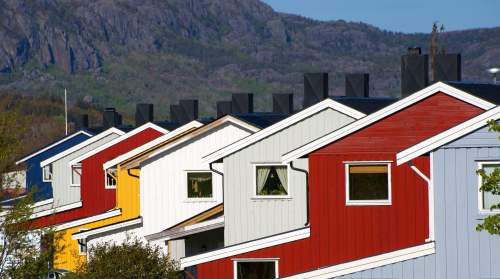Maschinellen Übersetzung Norwegisch - Deutsch. Auf dem Foto sind Holzhausfassaden zu sehen.